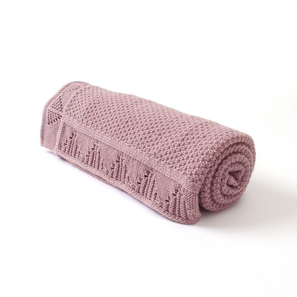 Comfy pink knitted blanket rolled up